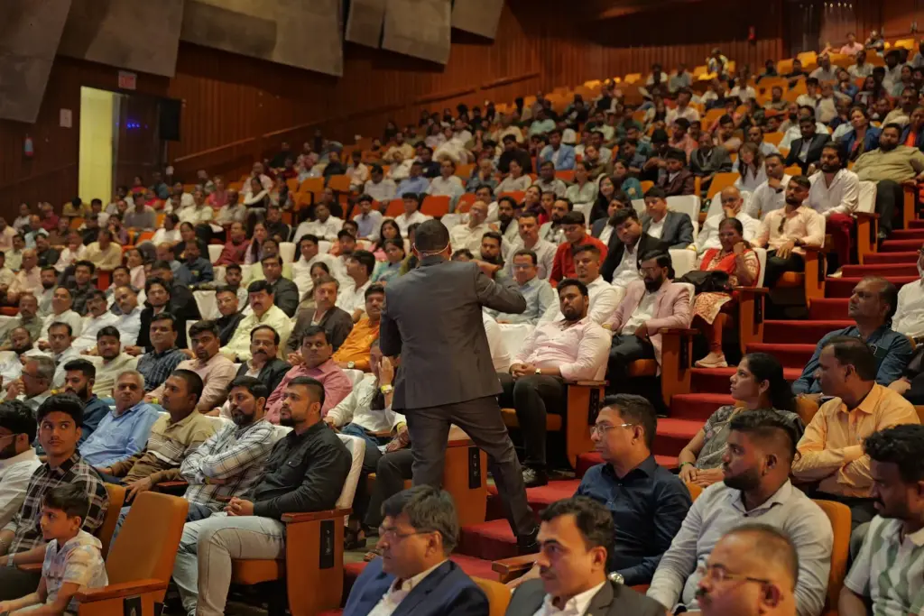 Dilip Auti speaking among business owners in the audience